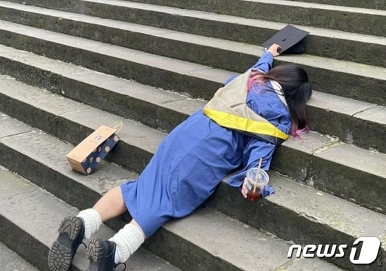 한 대학생이 계단 위에 대자로 누워 있다. - 웨이보 갈무리