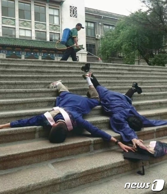 두 대학생이 계단위에 대자로 누워 있는 가운데, 미화원이 무심히 청소를 하고 있다-웨이보 갈무리