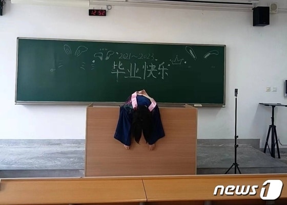 한 대학생이 교탁 위에 축 늘어져 있다. 칠판에는 '졸업축하'라는 글이 쓰여 있다 - 웨이보 갈무리