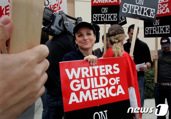 미국작가조합(WGA)를 지지하는 손팻말을 든 할리우드 여배우 줄리아 루이스 드레이퍼스. © 로이터=뉴스1