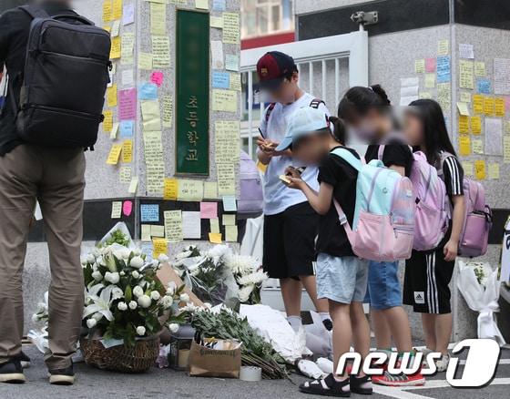 20일 오전 서울 서초구의 한 초등학교 정문에서 학생들이 추모 메시지를 적고 있다. 서울시교육청 등에 따르면, 지난 18일 오전 이 학교 1학년 담임인 A씨(23)가 극단적인 선택으로 사망하는 일이 발생했다. 2023.7.20/뉴스1 © News1 구윤성 기자