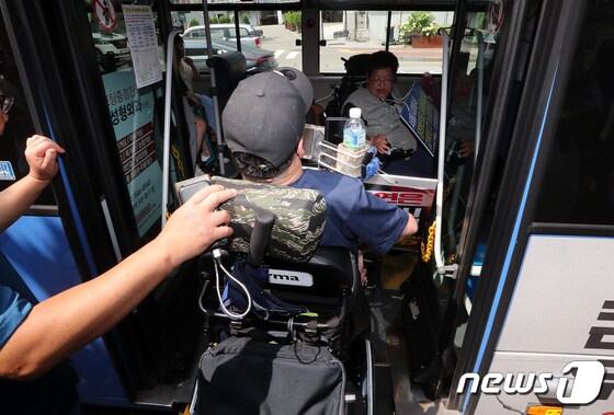 전국장애인차별철폐연대 활동가들이 장애인 이동권 관련 시위를 위해  저상버스에 탑승하고 있다. 2023.7.25/뉴스1 © News1 김진환 기자