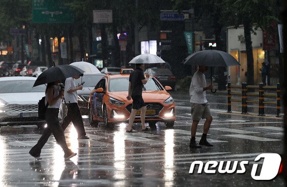 30일 오후 서울 종로 거리에서 우산을 쓴 시민들이 소나기를 피해 걷고 있다. 2023.7.30/뉴스1 © News1 구윤성 기자