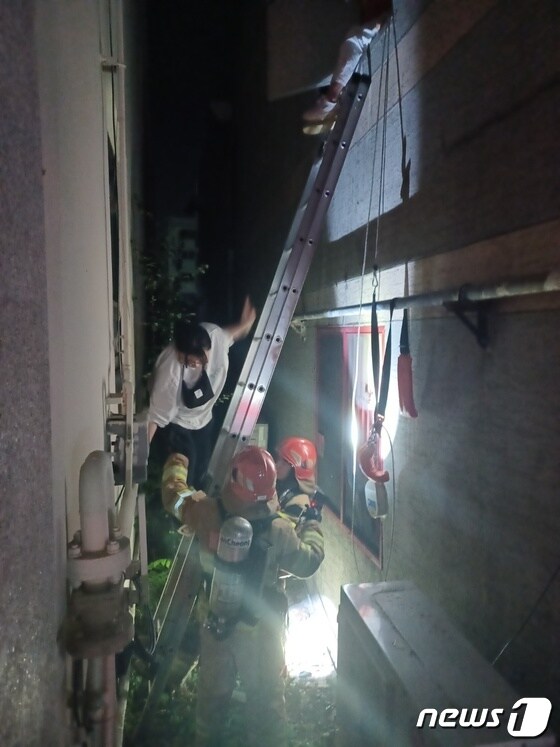 11일 오후 11시 12분께 불이 난 울산시 북구 연암동의 한 PC방 건물에서 대피 중인 시민들을 소방대원들이 돕고 있다.(울산소방본부 제공)