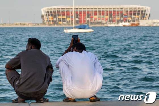 4일(현지시간) 카타르 도하의 2022 피파 월드컵 경기장 앞 걸프 해안가에 사람들이 더위를 피해 쪼그려 앉아 있다. 2023.08.04/ © AFP=뉴스1 © News1 권진영 기자