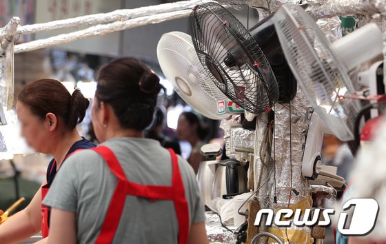 7일 서울 시내 전통시장에서 상인들이 선풍기 바람으로 더위를 식히고 있다. © News1 김민지 기자