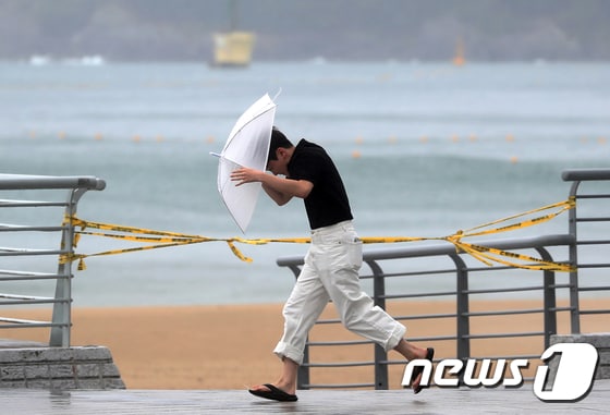 부산 해운대구 엘시티 인근에서 강한 비바람에 한 시민이 우산을 부여 잡고 걷는 모습. 뉴스1 © News1 윤일지 기자
