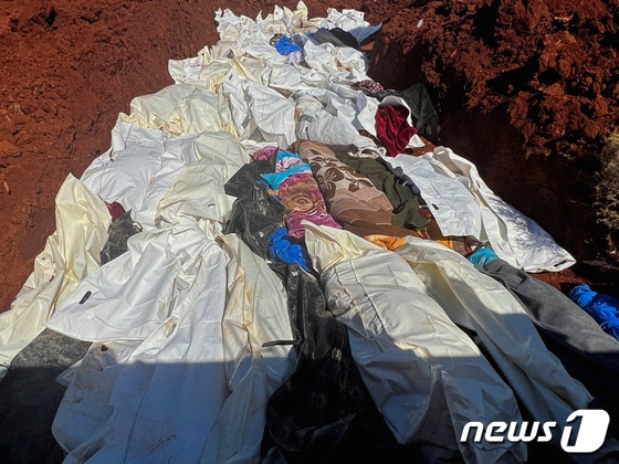12일(현지시간) 폭우로 대규모 인명피해가 발생한 리비아 동부 데르나시에서 시신들을 한 구덩이에 넣고 집단 매장하고 있다. © 로이터=뉴스1 © News1 박형기 기자