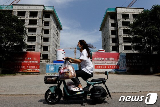 18일(현지시간) 중국 톈진에서 스쿠터를 탄 시민 한명이 부동산 개발업체 '컨트리 가든'이 건설하는 주거 단지 개발구역을 지나고 있다. 2023.09.18/ © 로이터=뉴스1 © News1 장성희 기자