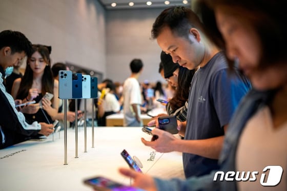 22일(현지시간) 아이폰15 시리즈 신제품 출시 첫날 중국 상하이의 애플 매장에서 고객들이 제품을 살펴 보고 있다. 가운데에는 아이폰15 프로 모델이 전시돼있다. 2023.09.22 © 로이터=뉴스1 © News1 우동명 기자