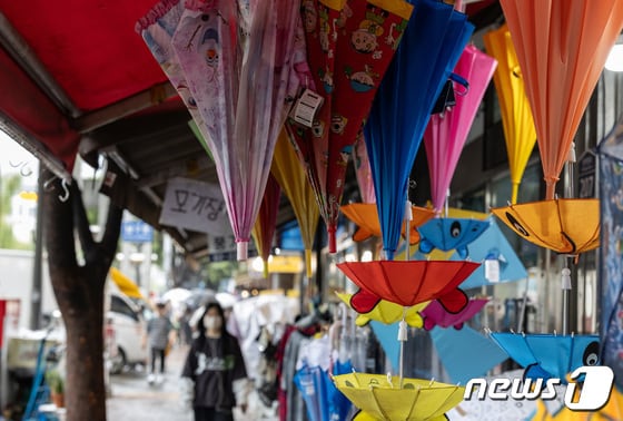 비가 내린 27일 오전 서울 종로구 광장시장에 위치한 우산 판매점 앞으로 한 시민이 지나가고 있다. 2023.9.27/뉴스1 © News1 이재명 기자