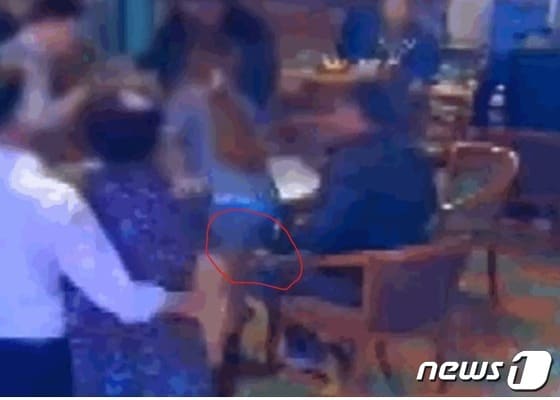  지난해 12월 전북 익산의 한 술집에서 한 남성이 여 직원 치마속에 손(붉은 원)을 집어넣고 있다. (jtbc  갈무리) © 뉴스1