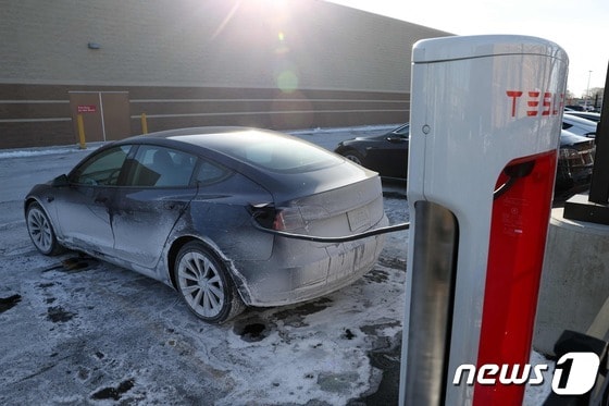 17일(현지시간) 한파가 들이닥친 미국 일리노이주 시카고에서 한 테슬라 차량이 얼음으로 덮인 주차장에서 배터리를 충전하고 있다. © AFP=뉴스1 © News1 박주평 기자