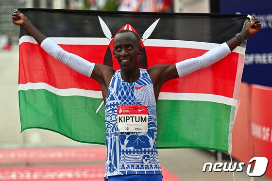 킵텀이 시카고 마라톤대회 우승 직후 케냐 국기를 들고 기뻐하고 있다. © 로이터=뉴스1 © News1 박형기 기자