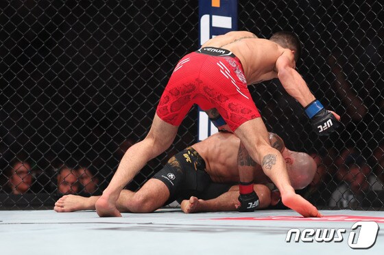 UFC 페더급 챔피언 알렉산더 볼카노프스키(아래)가 도전자 일리야 토푸리아에게 펀치를 맞고 쓰러지고 있다. © AFP=뉴스1