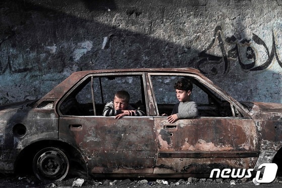 28일(현지시간) 가자지구 남부 라파에서 어린이들이 불에 탄 자동차에 탄 채 밖을 바라보고 있다. 2024.02.28 © AFP=뉴스1 © News1 정지윤 기자