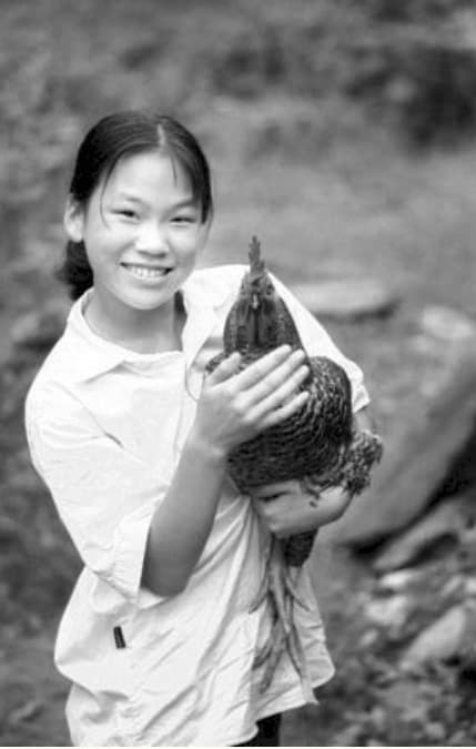  순박한 미소를 머금은 채 닭을 들고 있는 산골소녀 영자. (SNS 갈무리) © 뉴스1