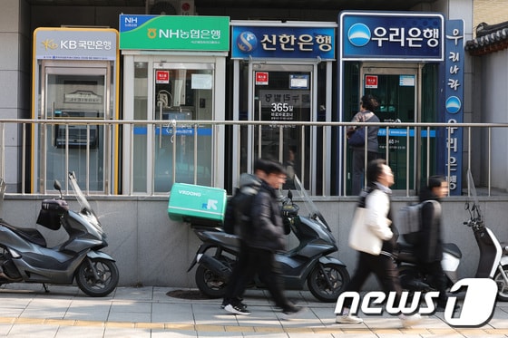 서울 시내에 설치된 시중은행 ATM 기기 앞을 시민들이 지나가고 있다. © News1 신웅수 기자