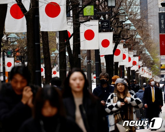 일본 도쿄의 한 상점가에서 시민들이 일장기가 걸린 길을 따라 걷고 있다. 2024.03.19. © 로이터=뉴스1