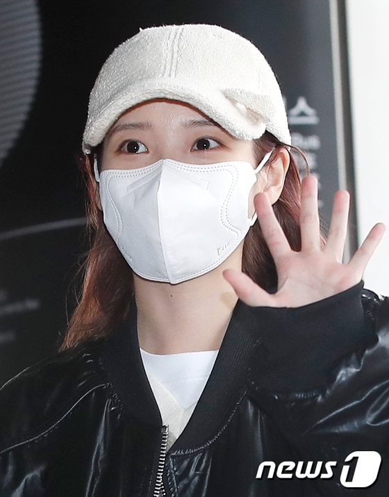 가수 아이유가 해외 일정을 위해 22일 김포공항에 도쿄로 출국하기 전 인사를 하고 있다.  © News1 권현진 기자