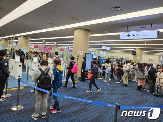 25일 오전 11시쯤 김해국제공항을 통해 입국하고 있는 대만 여행객들이 자동검역심사대(왼쪽 4대)를 통과 하고 있다. 반면 대면 검역심사대(오른쪽)에는 여행객들이 줄을 길게 서 있다.