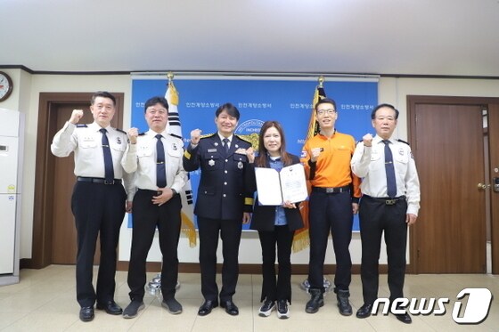  임민자 씨(54·사진 오른쪽에서 세번째)가 특별유공 시민 표창장을 수여하고 있는 모습.(인천 계양소방서 제공)/뉴스1