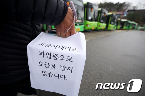 서울 시내버스 노조가 파업에 돌입한 28일 서울의 한 공영차고지에서 일부 운행 버스의 기사가 '파업중으로 요금을 받지 않습니다'라는 게시물이 붙은 요금통을 들고 이동하고 있다. 서울시버스노동조합은 이날 오전 사측인 서울시버스운송사업조합과의 협상 결렬을 선언, 전체 서울 시내버스(7천382대)의 97.6%에 해당하는 7천210대가 운행을 멈췄다. 서울 시내버스 파업은 12년 만이다. 2024.3.28/뉴스1 © News1 이광호 기자