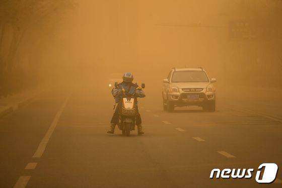 27일(현지시간) 중국 내몽골 자치구 에렌호트의 거리에서 주민이 짙은 황사 속에 오토바이를 타고 있다. 2024.3. 29 © AFP=뉴스1 © News1 우동명 기자