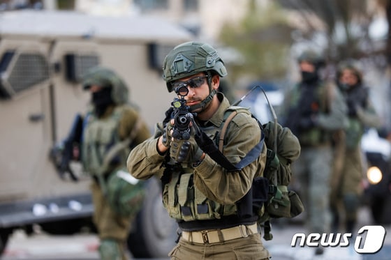 4일 요르단강 서안 라말라(팔레스타인 임시 행정 수도)에서 이스라엘 군인이 공습 중 위치를 잡으며 무기를 조준하고 있다. 2024.03.04 © 로이터=뉴스1 