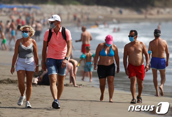 스페인령 카나리아 제도의 플라야 델 잉글레스에 위치한 해변에서 여행객들이 산책하고 있다. 2020.12.1 © 로이터=뉴스1 © News1 강민경 기자