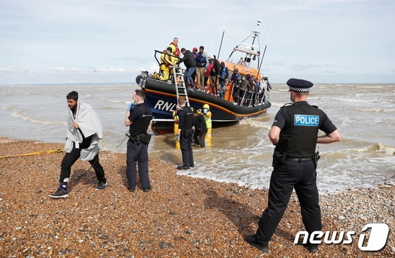 영국 던게니스 항구에서 경찰들이 보트를 타고 온 난민들을 육지로 인도하고 있다. 2021.09.13/ © 로이터=뉴스1 © News1 권진영 기자