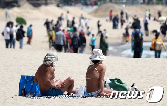전국적으로 초여름 날씨를 보인 14일 부산 해운대해수욕장을 찾은 시민들이 태닝을 즐기고 있다. 2024.4.14/뉴스1 © News1 윤일지 기자