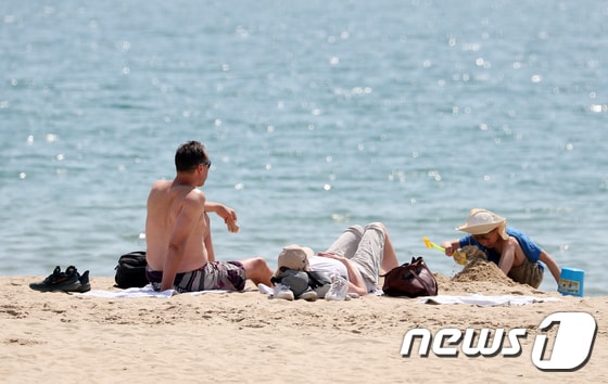 부산 해운대해수욕장을 찾은 외국인 가족이 태닝을 즐기고 있다. 2024.4.14/뉴스1 © News1 윤일지 기자