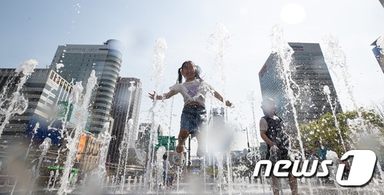 서울 낮 최고기온이 30도까지 오르는 등 초여름 날씨가 이어진 14일 서울 광화문광장 분수대에서 어린이들이 물놀이를 즐기며 더위를 식히고 있다. 2024.4.14/뉴스1 © News1 유승관 기자