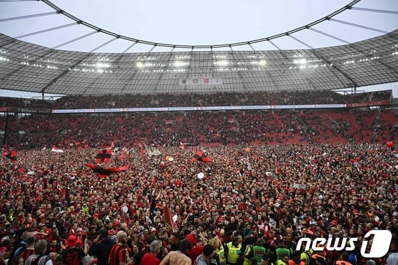 레버쿠젠 팬들이 120년 만의 우승에 감격해 그라운드에 내려와 기뻐하고 있다.  © AFP=뉴스1