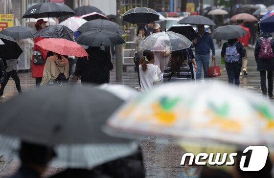 전국 대부분 지역에 비가 내리는 15일 오후 서울 중구 명동거리에서 외국인 관광객들이 발걸음을 재촉하고 있다. 2024.4.15/뉴스1 © News1 이재명 기자