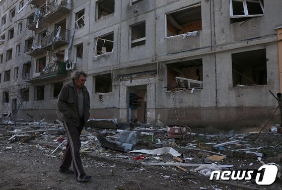 15일(현지시간) 우크라이나 도네츠크 아우디이우카 인근의 오케레틴 마을에서 한 남성이 포격과 공습으로 파괴된 주택 옆을 지나가고 있다. 2024.04.15/ © AFP=뉴스1 © News1 권진영 기자