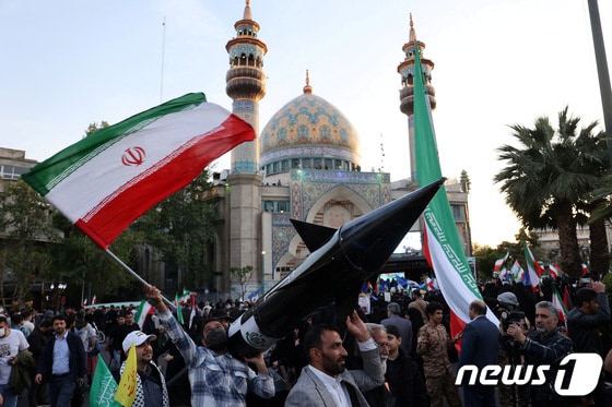 이란이 이스라엘을 공습하자 15일(현지시간) 테헤란에서 이란인들이 미사일 모형을 들고 자축하고 있다. 2024.04.15 © 로이터=뉴스1 © News1 정지윤 기자