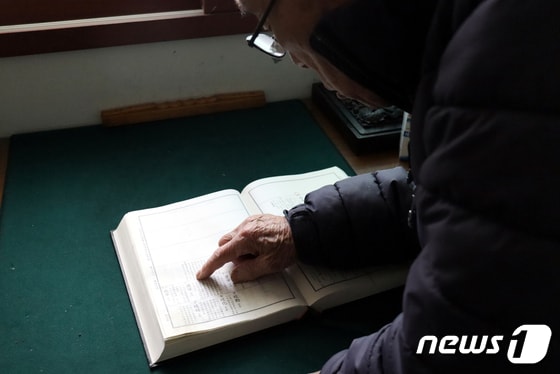 국군포로 유가족 이강복 씨가 충남 서산의 자택에서 북한으로 끌려간 가족들의 이름이 적힌 족보를 들춰보고 있다. 2023.12.26/뉴스1 © News1 박동해 기자
