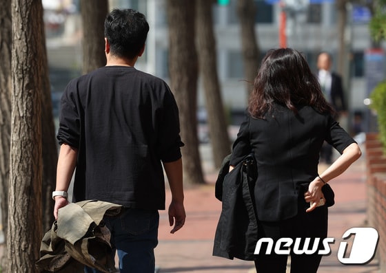  따뜻한 날씨 속  시민들이 외투를 들고 걸어가고 있다.(사진은 기사 내용과 무관함) / 뉴스1 © News1
