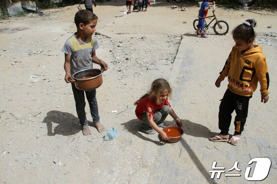 22일(현지시간) 가자지구 북부 자발리아에서 아이들이 음식이 담긴 냄비를 들고 있다. 2024.04.22 © 로이터=뉴스1 © News1 정지윤 기자