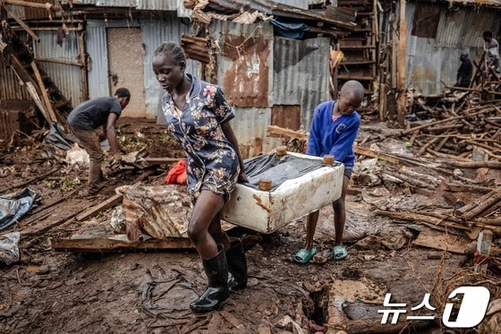 25일(현지시간) 케냐 나이로비의 한 마을에서 두 어린이가 홍수로 파괴된 집에서 살림살이를 꺼내 옮기고 있다. 2024.04.25/ © AFP=뉴스1 © News1 권진영 기자