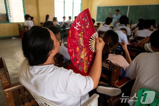 필리핀 메트로마닐라 퀘존시티의 한 고등학교에서 한 학생이 더위를 식히기 위해 부채질을 하고 있다. 2024.04.18 © 로이터=뉴스1 © News1 정지윤 기자