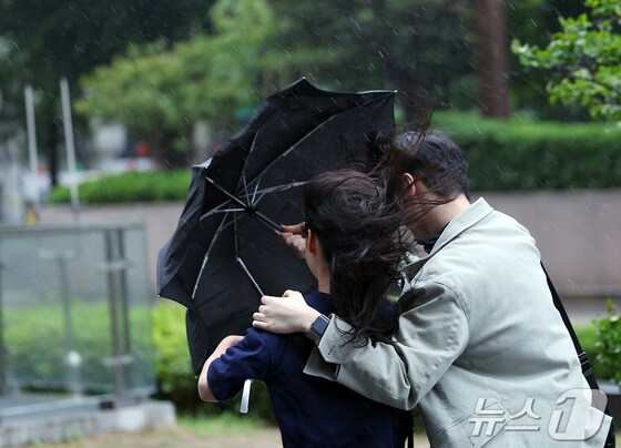 전국에 강풍을 동반한 비가 예고된 11일 오후 서울 종로구 도심을 지나는 한 시민들이 강한 바람에 위태로운 모양의 우산에 의지한 채 발걸음을 재촉하고 있다.  2024.5.11/뉴스1 © News1 박정호 기자