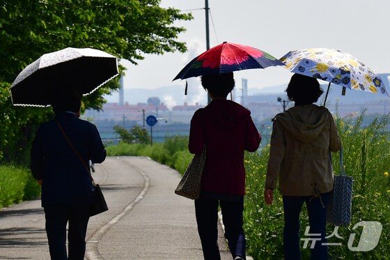  시민들이 양산을 쓰고 걸어가고 있다. © News1 최창호 기자