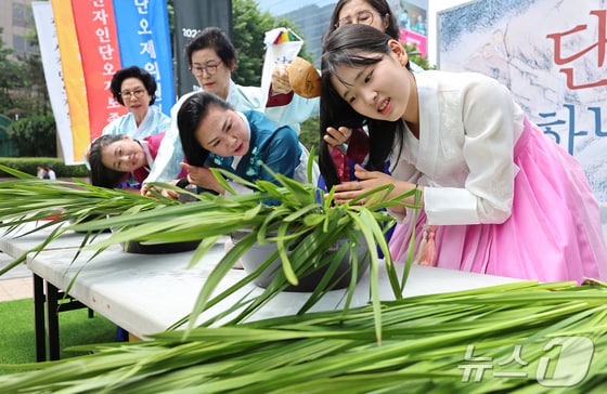 22일 서울 중구 청계광장에서 열린 전국단오제연합 주최 '단오, 단 하나가 되다'에서 참가자들이 창포물에 머리감기를 하고 있다. '단오, 단 하나가 되다'는 단오제 관련 단체들이 모여 단오제의 전통과 문화를 널리 알리고 지역 간 교류와 협력을 강화하기 위해 마련됐다. 2024.5.22/뉴스1 ⓒ News1 김도우 기자