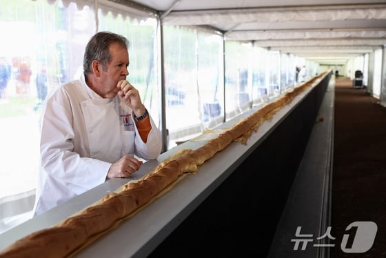 5일(현지시간) 프랑스 파리 근교 쉬렌에서 열린 바게트 쇼에서 세계에서 가장 긴 바게트 만들기에 도전한 제빵사가 오븐에서 나오는 바게트 근처에 서 있다. 2024.05.05/ © 로이터=뉴스1 © News1 권진영 기자