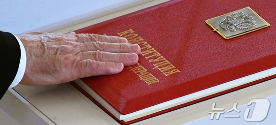 푸틴이 헌법에 오른손을 올려 선서하고 있다. 2024.05.08 © 로이터=뉴스1 © News1 우동명 기자