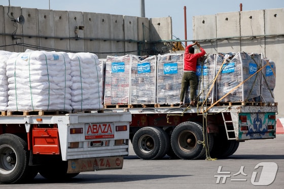 이스라엘 남부 케렘 샬롬 검문소에서 한 트럭 기사가 가자지구로 향하는 구호품을 밧줄로 고정하고 있다. 2024.03.14/ © 로이터=뉴스1 © News1 권진영 기자