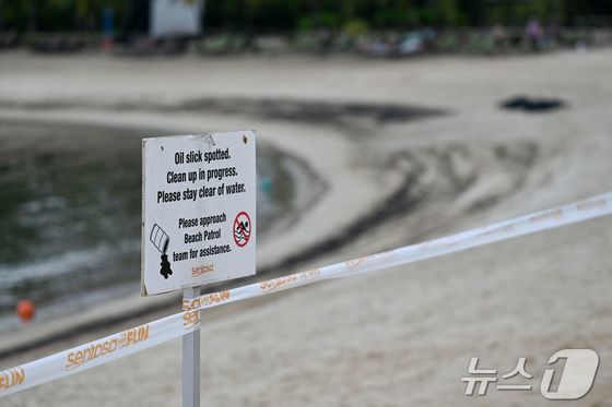 15일 싱가포르 센토사섬의 실로소 해변에 기름 유출에 관한 표지판이 세워져 있다. 2024.06.15/뉴스1 © AFP=뉴스1 © News1 조소영 기자